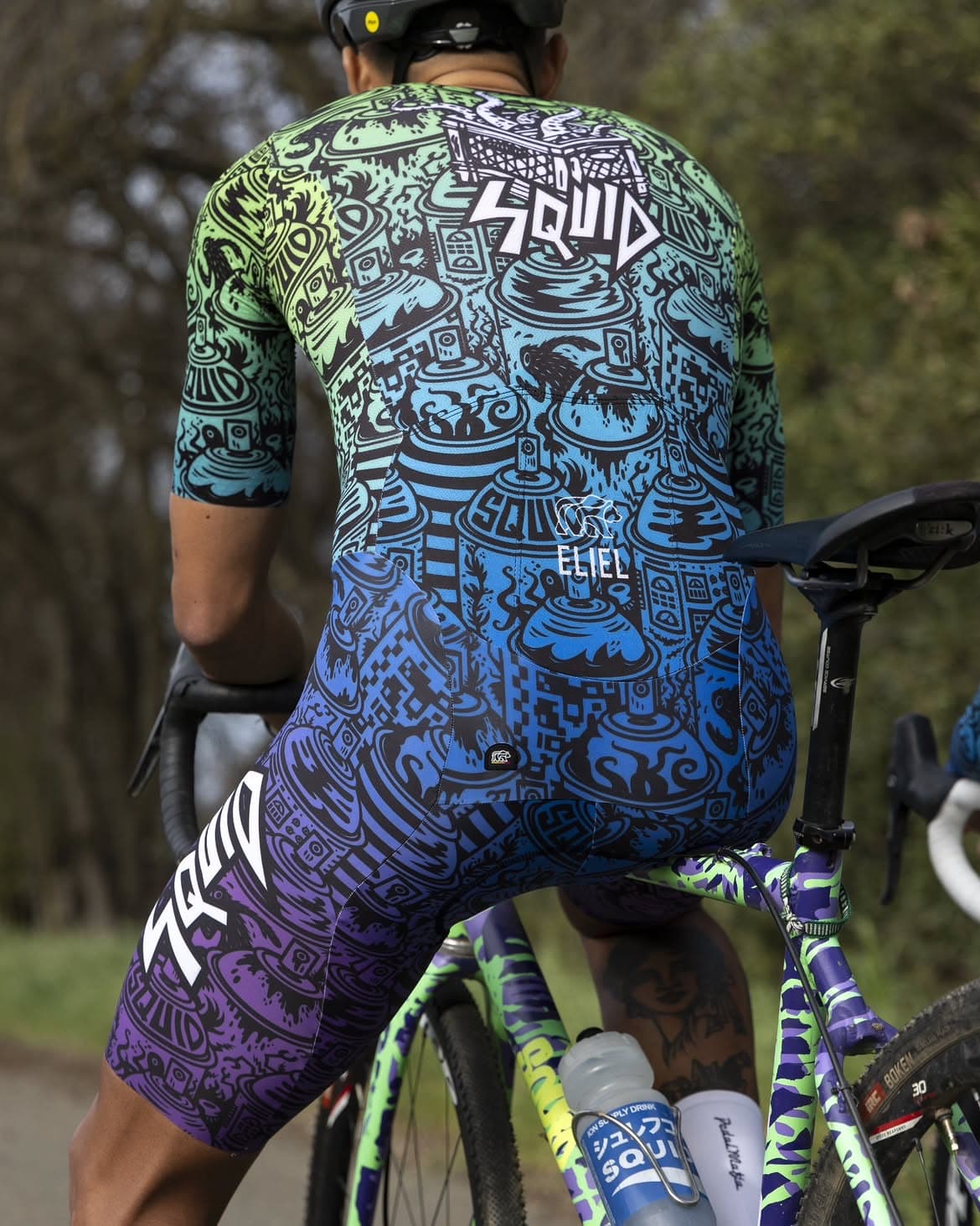 Rear view of a green, blue, and purple illustrated Squid cycling kit